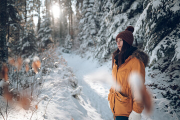 Femme jeune et belle en hiver dans la forêt froide et enneigée