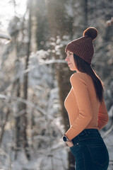Femme jeune et belle en hiver dans la forêt froide et enneigée