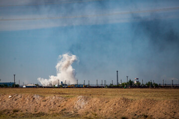 Fototapeta na wymiar Panorama view on steppe and explosion. White cloud and black smoke. Coal quarry in Kazakhstan.