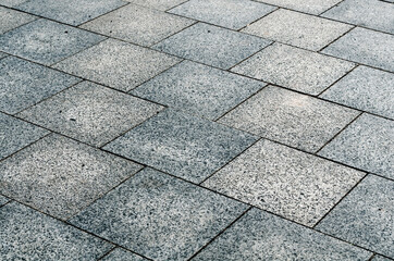 Sidewalk gray square tiles in two shades, laid out diagonally, background