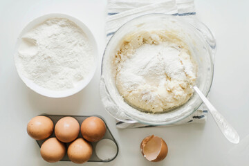 Cooking raw ingredients on white table, making cake.