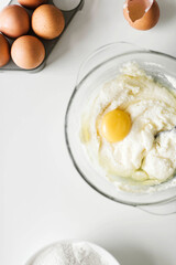 Cooking raw ingredients on white table, making cake.