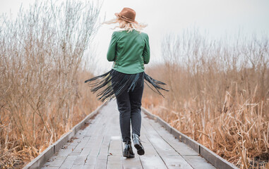 Woman wear eco leather green jacket, Fedora brown hat and vintage aviator glasses , belt with a...