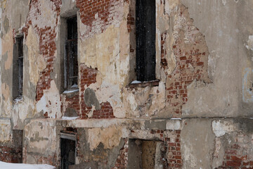 Brick wall with peeling plaster. A very old and abandoned building