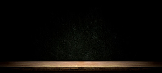 Empty wooden table on black, dark and gray abstract stone wall,studio room gradient background to...