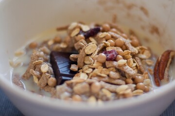 bowl of homemade muesli cereal breakfast with salted caramel and dark chocolate in a bowl