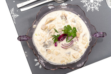 Raw herring in cream, standing in a glass vase on a holiday table in Poland, isolated on a white...