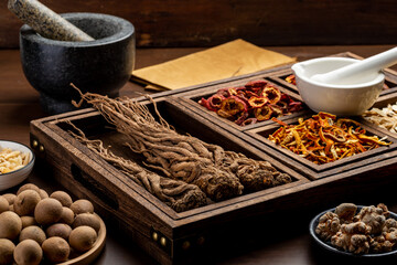 Ancient Chinese medicine books and herbs on the table