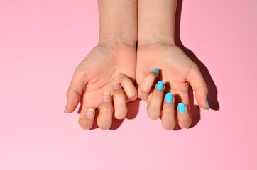 Fototapeta premium Stylish trendy female manicure. Beautiful young woman's hands on pink and purple background.