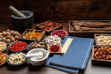Ancient Chinese medicine books and herbs on the table