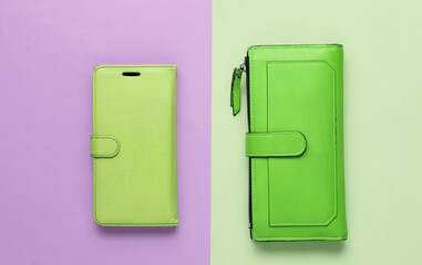 Studio fashion shot. Green wallet, smartphone in a leather case on colored pastel background. Top view