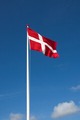 The danish flag with blue sky on background