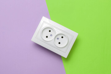 Double power socket on green purple background. Top view. Studio shot
