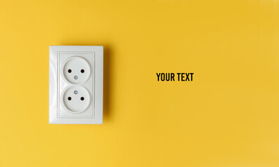 Double power socket on a yellow wall. Studio shot. Minimalism. Copy space - obrazy, fototapety, plakaty