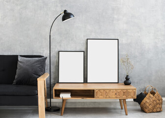 Blank picture frames mockup on gray wall. White living room design. View of modern scandinavian style interior with sofa. Home staging and minimalism concept. Artwork poster showcase