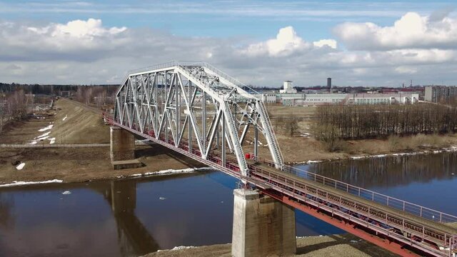 Metal railway train bridge over the river
Belarus Orsha Dnieper River. 
early spring Aerial footage from drone straight backward landscape revealing panorama