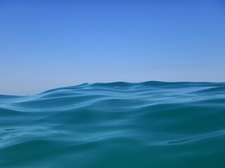 Great wave on the blue open sea with blue sky only in background
