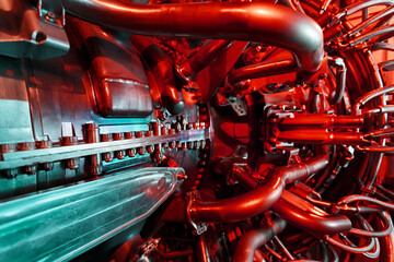 A modern gas turbine aircraft engine in a futuristic red-green light.