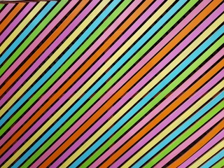 Diagonales parallèles et colorées selon une alternance passant du violet, au jaune, au bleu, au vert, au violet, à l'orange. Chaque bande de couleur es séparée de la suivante par une bande noire plus 