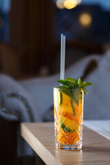 Coctail with lime and orange with mint on wooden table