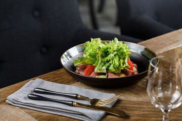 Plate of salad with lettuce, tomatoes and meat