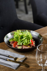 Plate of salad with lettuce, tomatoes and meat