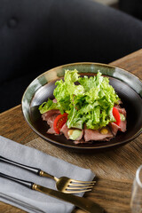 Plate of salad with lettuce, tomatoes and meat