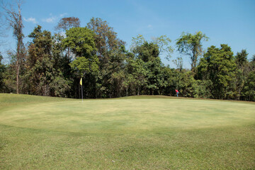 Golfer playing golf in the evening golf course, on sun set evening time. Man playing golf on a golf course in the sun.