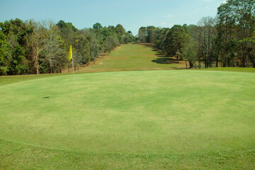 Background of evening golf course has sunlight shining down at golf course.