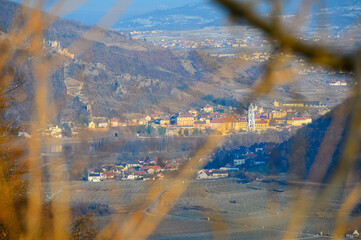 A view from behind a tree over vineyards and Dürnstein ruins in the early spring on a sunny day