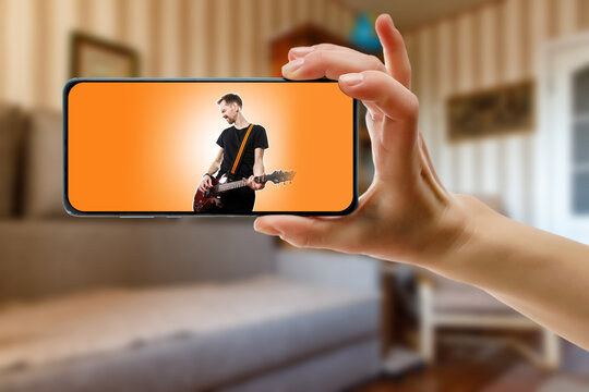 Watching online music performance by the singer at home by smartphone.
