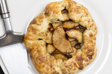 Rustic apple pie on white plate with server - top view photo