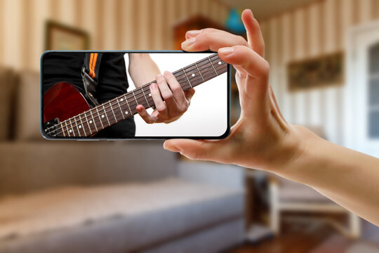 Guitar lessons tutorial with smart phone. Indoor screen shot of musical course