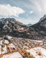 Aerial drone shot of picturesque Neuschwanstein Castle on snowy hill in winter sunlight in Germany - obrazy, fototapety, plakaty