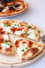 Pizza on a wooden board with mozzarella, mini arugula.