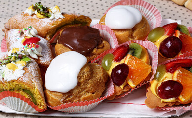 Vassoio con pasticcini misti al cioccolato frutta e vaniglia disposto su tavola per un party.