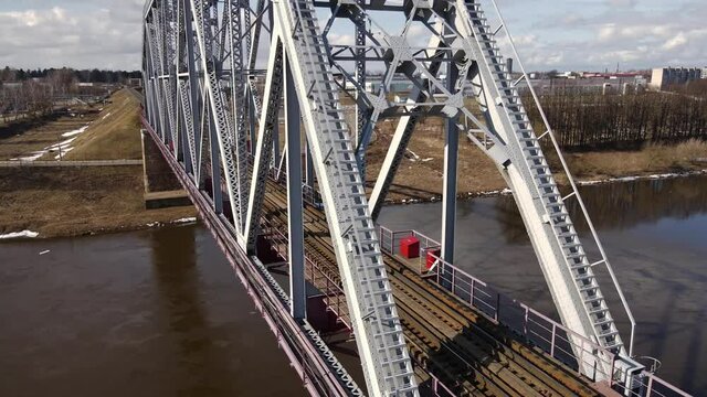 Metal railway train bridge over the river
Belarus Orsha Dnieper River. 
early spring Aerial footage from drone close orbital side panorama