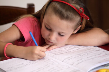Bambina mentre scrive sul quaderno 