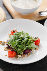 Arugula salad with tomatoes on white plate