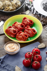 Red color dumplings on wooden table with souce