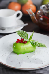Green colored dessert with basil served with teapot