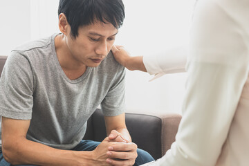 Young asian man, male suffers from a mental who needs to therapy with a psychologist while sitting...
