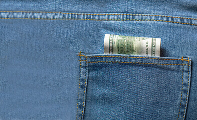 Money in my jeans pocket. Dollars in the back pocket of blue jeans.  Place for text. Copy space.