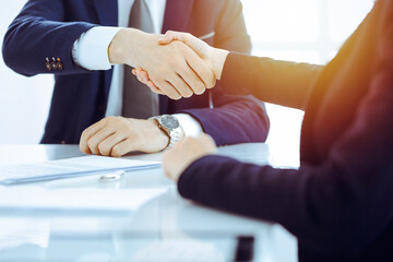 Fototapeta na wymiar Businesspeople or lawyers shaking hands finishing up meeting or negotiation in sunny office. Business handshake and partnership