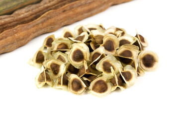 Pile of Moringa seed and moringa pods isolated on white background. The dried seeds in the pod are ready for propagate. Natural herbs can be extracted into oil for healthcare.
