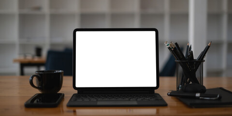 White blank screen tablet on modern working desk.