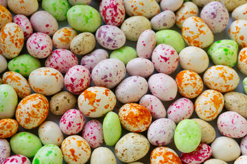 Happy Easter. Lots of colored candy in the form of Easter eggs. Color background. Dragon eggs.