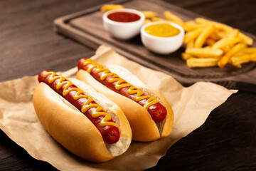 Hot dogs with ketchup, yellow mustard and french fries.