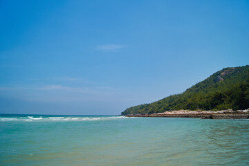 Fototapeta na wymiar Green island in Thailand near the sea, against the blue sky