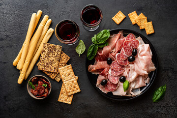 Appetizers with differents antipasti, charcuterie, snacks and red wine. Sausage, ham, tapas, olives...